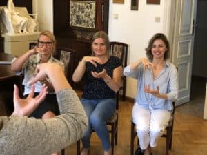 Trzy kobiety uczą się języka migowego.